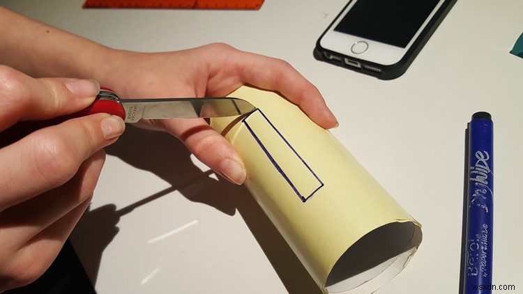 केवल एक टॉयलेट रोल और कुछ पिन का उपयोग करके एक सस्ता iPhone स्टैंड कैसे बनाएं 